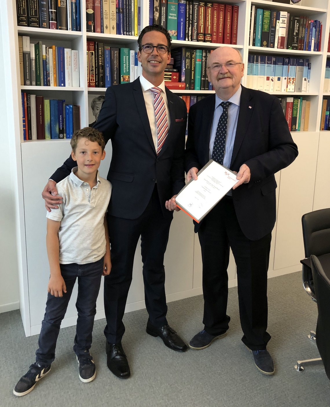 Prof. Dr. Marc Busche erhält in Begleitung seines stolzen Sohnes Maximilian (9 Jahre) seine Urkunde im Büro des Präsidenten der Medizinischen Hochschule Hannover (MHH) von Univ.-Prof. Dr. med. Michael P. Manns.