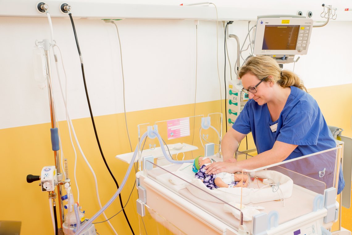 Pflegerin kümmert sich um ein Neugeborenes