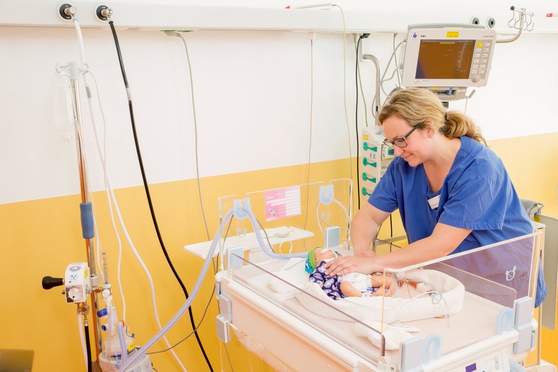 Intermediate Care Kinderklinik Pflegerin kümmert sich um ein Neugeborenes