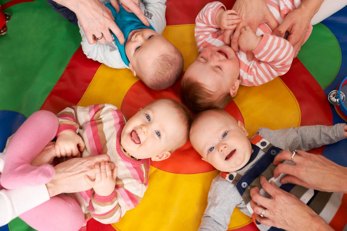 Vier Säuglinge auf einer Decke