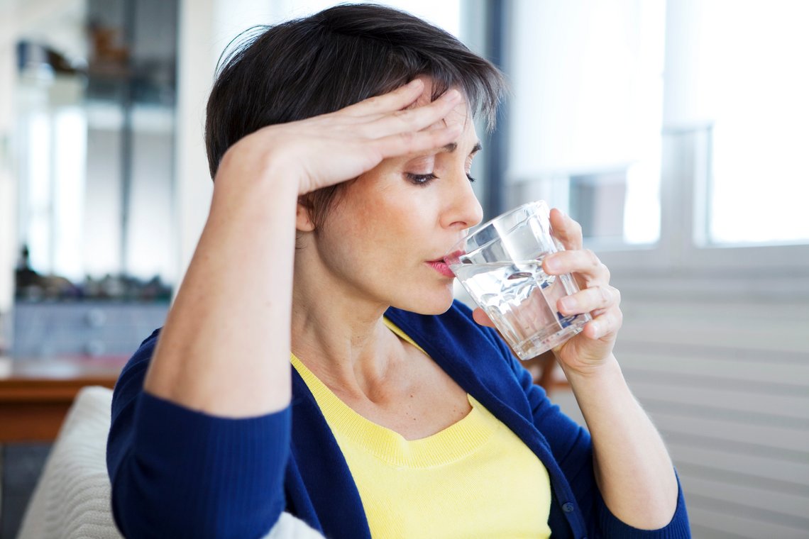 Frau trinkt Wasser aus Glas