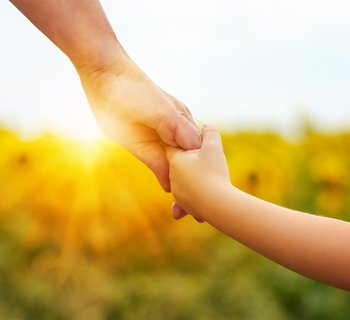 Muter und Kind halten Hände