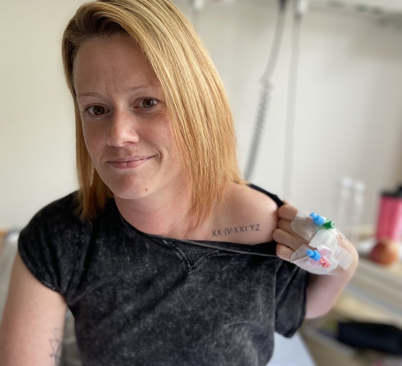Frau zeigt Tattoo an der Schulter