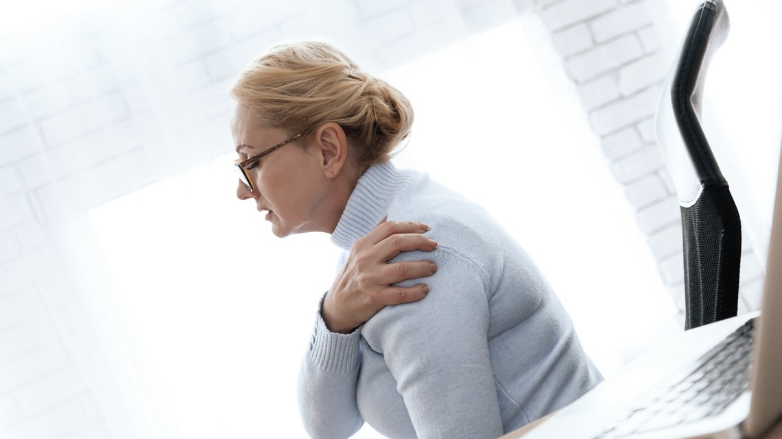Frau mit Schulterschmerzen