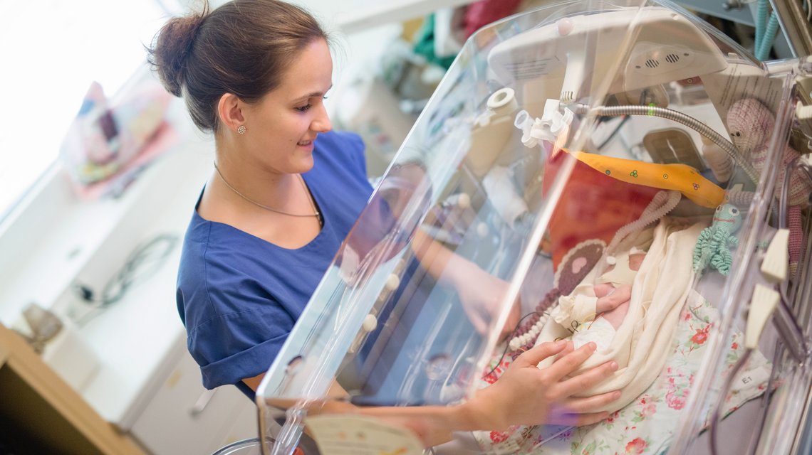 Pflegerin und Säugling im Inkubator