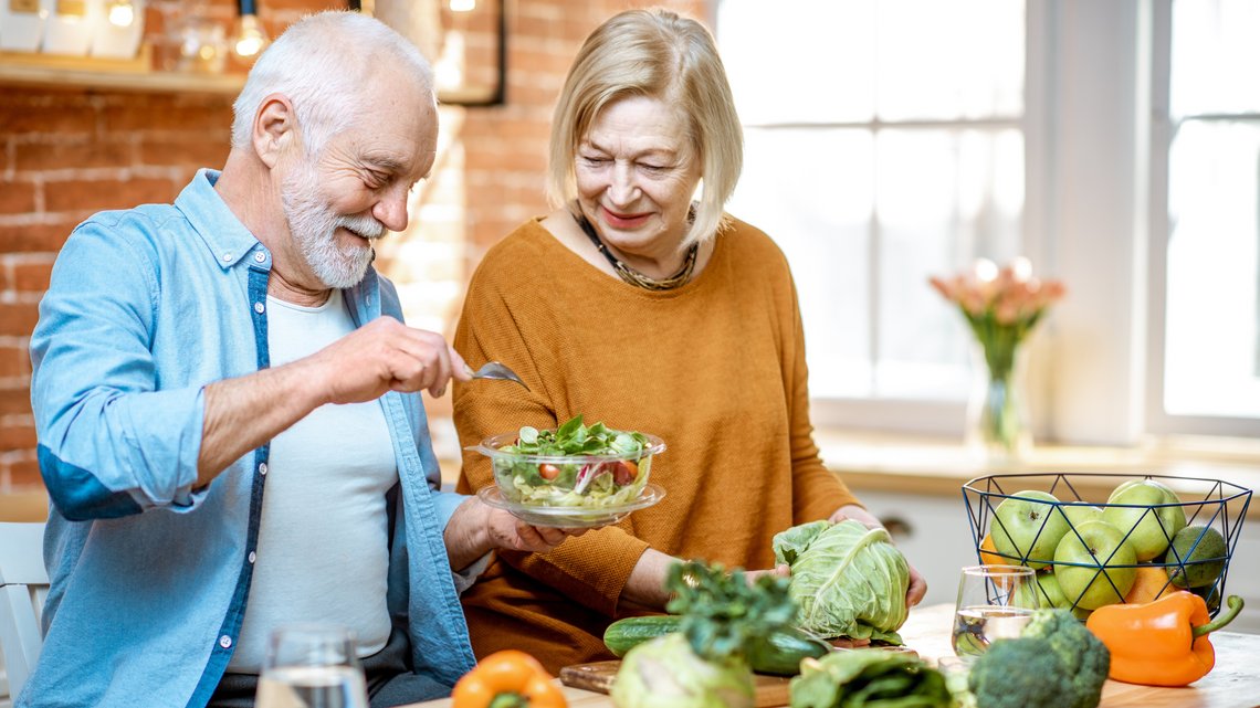 Älteres Paar beim Zubereiten von Salat